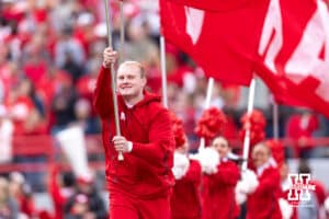 Nebraska Cornhuskers Cheer Squad runnning with the Nebraska flags after a touchdown during a college football game against the Northwestern Wildcats on Saturday, October 25, 2025, in Lincoln, Nebraska. Photo by John S. Peterson.