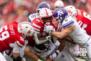 Nebraska Cornhusker running back Emmett Johnson (21) is tackled by Northwestern Wildcat defensive lineman Carmine Bastone (1) and defensive back Robert Fitzgerald (6) in the third quarter during a college football game on Saturday, October 25, 2025, in Lincoln, Nebraska. Photo by John S. Peterson.