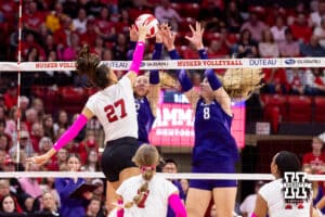 Nebraska Cornhusker outside hitter Harper Murray (27) spikes the ball against Northwestern Wildcat outside hitter Isabella Bullington (22) and middle blocker Gabrielle Gerry (8) in the third set during a college volleyball match on Friday, October 24, 2025, in Lincoln, Nebraska. Photo by John S. Peterson.