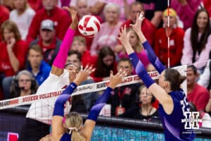 Nebraska Cornhusker outside hitter Taylor Landfair (12) spikes the ball against Northwestern Wildcat middle blocker Kayla Kauffman (4) and outside hitter Campbell Paris (25) in the first set during a college volleyball match on Friday, October 24, 2025, in Lincoln, Nebraska. Photo by John S. Peterson.