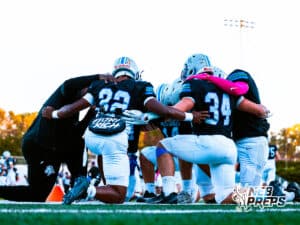 Millard North's Tierre Porter (32) and Austin Ruhter (34) are praying with teammates and coaches before a high school football game VS Omaha Central on Friday, October 17, in Omaha, Nebraska. Photo By Jack Stephens.
