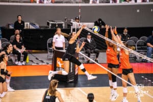 Team Thompson Molly McCage (#5) spikes the ball past Team Valentin-Anderson's block during the Athletes Unlimited Volleyball match against Team Valentin-Anderson on Monday, October 13, 2025, in Omaha, Nebraska. Photo by Dawson Anderson.
