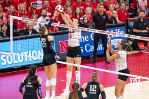 Nebraska Cornhusker Virginia Adriano (#9) blocks a hit during a college volleyball match against Washington on Friday, October 10, 2025, in Lincoln, Nebraska. Photo by Brandon Tiedemann.