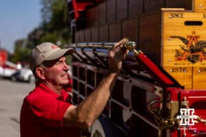 One of the Budweiser Clydesdale employees polishing the brass on the wagon preparing for the parade in East Stadium parking lot during a college football game on Saturday, October 4, 2025, in Lincoln, Nebraska. Photo by John S. Peterson.