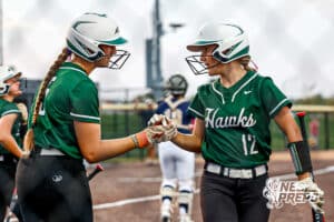 Lincoln Southwest's Maisey McCarty (15) and Taylor Siefken (12) high-fiving each other after scoring a run during a high school softball game @ Elkhorn South on Monday, September 29, 2025, in Omaha, Nebraska. Photo By Jack Stephens.