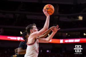 Nebraska Cornhusker forward Pryce Sandfort (21) makes a lay up against Winthrop Eagle forward Pharell Boyogueno (4) in the second half during a college basketball game on Tuesday, Nov. 25, 2025, in Lincoln, Nebraska. Photo by John S. Peterson.