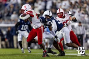 Nebraska Cornhusker running back Emmett Johnson (21) runs with the ball against Penn State Nittany Lion defensive end Dani Dennis-Sutton (33) in the first quarter during a college football game on Saturday, Nov. 22, 2025, in State College, PA. Photo by John S. Peterson.
