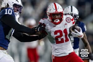 Nebraska Cornhusker running back Emmett Johnson (21) stiff arms Penn State Nittany Lion safety Dejuan Lane (10) in the first quarter during a college football game on Saturday, Nov. 22, 2025, in State College, PA. Photo by John S. Peterson.
