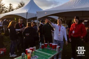 Nebraska Cornhusker fan playing beer pong at at a tailgate with Penn State fans before a college football game on Saturday, Nov. 22, 2025, in State College, PA. Photo by John S. Peterson.