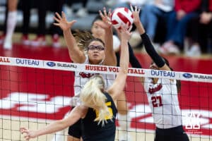 Nebraska Cornhuskers middle blocker Rebekah Allick (5) and outside hitter Harper Murray (27) jump up to block a spike from Iowa Hawkeye outside hitter Carmel Vares (15) in the second set during a college volleyball match on Thursday, Nov. 20, 2025, in Lincoln, Nebraska. Photo by John S. Peterson.