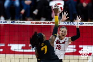 Nebraska Cornhusker middle blocker Andi Jackson (15) jumps to block a spike from Iowa Hawkeye outside hitter Chard'E Vanzandt (7) in the second set during a college volleyball match on Thursday, Nov. 20, 2025, in Lincoln, Nebraska. Photo by John S. Peterson.