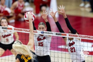Nebraska Cornhusker middle blocker Andi Jackson (15) and outside hitter Harper Murray (27) jump to block a spike from Iowa Hawkeye outside hitter Carmel Vares (15) int e first set during a college volleyball match on Thursday, Nov. 20, 2025, in Lincoln, Nebraska. Photo by John S. Peterson.