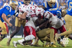 Nebraska Cornhuskers defensive lineman Elijah Jeudy (16) and linebacker Dylan Rogers (52) tackle UCLA Bruin quarterback Nico Iamaleava (9) during a college football game on Saturday, November 8, 2025, in Pasadena, California. Photo by John S. Peterson.