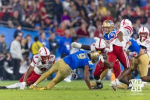 Nebraska Cornhuskers linebacker Vincent Shavers Jr. (9) and defensive back Deshon Singleton (8) make the stop against UCLA Bruin quarterback Nico Iamaleava (9) during a college football game on Saturday, November 8, 2025, in Pasadena, California. Photo by John S. Peterson.