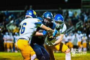 Concordia's Alex Eschmann (44) is getting tackled by two warriors during a high school football game against Wahoo on Friday, October 24, 2025 in Omaha, Nebraska. Photo By Jack Stephens.