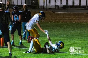 Wahoo's Josh Fox (8) is helping up his teammate Cody Hesser (15) after scoring a touchdown during a high school football game at Concordia on Friday, October 24, 2025 in Omaha, Nebraska. Photo By Jack Stephens.