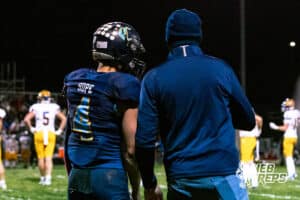Concordia's Drew Kulus (4) and Head Coach Adolph Shepardson going over a play before calling it during a high school football game against Wahoo on Friday, October 24, 2025 in Omaha, Nebraska. Photo By Jack Stephens.