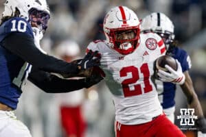 Nebraska Cornhusker running back Emmett Johnson (21) stiff arms Penn State Nittany Lion safety Dejuan Lane (10) in the first quarter during a college football game on Saturday, Nov. 22, 2025, in State College, PA. Photo by John S. Peterson.