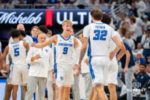 Creighton's Ty Davis celebrates with Jasen Green and Owen Freeman during a timeout. Creighton men's basketball hosts Marquette at CHI Health Center on Saturday, Dec 20, 2025, in Omaha, Nebraska. Photo by Kyle Byers.