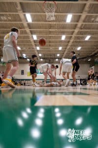 A Pius X defender is helped off the deck after a play during a high school basketball game Thursday, December 11, 2025, in Lincoln, Nebraska. Photo by Braden Cochran.