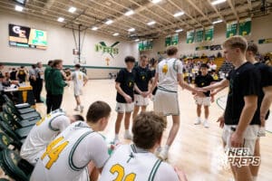 Lincoln Pius X player Zach Taubenheim (4) is welcomed to the court by teammates before a high school basketball game Thursday, December 11, 2025, in Lincoln, Nebraska. Photo by Braden Cochran.