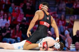 Nebraska Cornhusker Christopher Minto shoves North Carolina Tar Heel Collin Carrigan face into the mat during a college wrestling duel at 174 on Friday, Dec 19, 2025, in Lincoln, Nebraska.