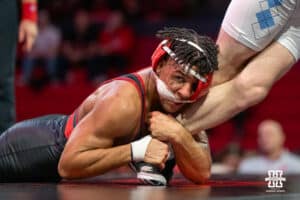 Nebraska Cornhusker Christopher Minto grabs North Carolina Tar Heel Collin Carrigan’s ankle during a college wrestling duel at 174 on Friday, Dec 19, 2025, in Lincoln, Nebraska.