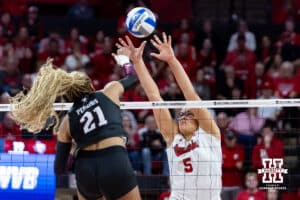 Texas A&M Aggie middle blocker Morgan Perkins (21) spikes the ball against Nebraska Cornhusker middle blocker Rebekah Allick (5) in the fourth set during the NCAA Volleyball Regional on Sunday, Dec. 14, 2025, in Lincoln, Nebraska. Photo by John S. Peterson.