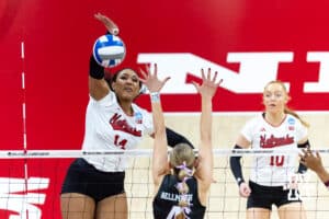 Nebraska Cornhusker middle blocker Manaia Ogbechie (14) spikes the ball for a kill against Texas A&M Aggie outside hitter Emily Hellmuth (4) in the first set during the NCAA Volleyball Regional on Sunday, Dec. 14, 2025, in Lincoln, Nebraska. Photo by John S. Peterson.