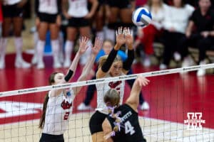 Nebraska Cornhusker setter Bergen Reilly (2) and middle blocker Andi Jackson (15) jump up to block Texas A&M Aggie outside hitter Emily Hellmuth (4) in the first set during the NCAA Volleyball Regional on Sunday, Dec. 14, 2025, in Lincoln, Nebraska. Photo by John S. Peterson.