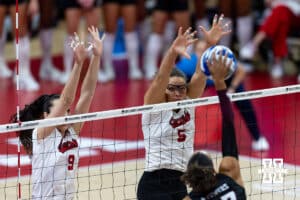 Nebraska Cornhusker middle blocker Rebekah Allick (5) and opposite Virginia Adriano (9) jump up to block Texas A&M Aggies in the first set during the NCAA Volleyball Regional on Sunday, Dec. 14, 2025, in Lincoln, Nebraska. Photo by John S. Peterson.