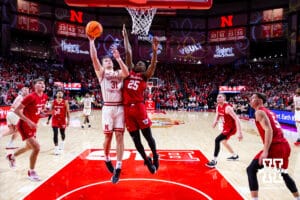 Nebraska Cornhusker guard Cale Jacobsen (31) makes a lay up against Wisconsin Badger guard John Blackwell (25) in the first half during a college men’s basketball game on Wednesday, Dec. 10, 2025, in Lincoln, Nebraska. Photo by John S. Peterson.