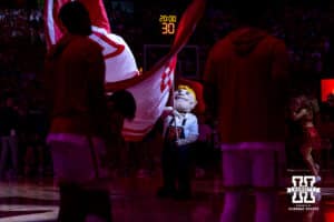 Nebraska Cornhusker mascot Herbie waves the Nebraska flag during the introductions before a college basketball game against the Creighton Bluejays on Sunday, Dec. 7, 2025, in Lincoln, Nebraska. Photo by John S. Peterson.