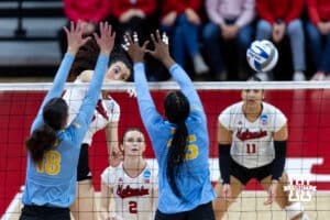 Nebraska Cornhusker opposite Virginia Adriano (9) spikes the ball against LIU Shark outside hitter Sara van Gisteren (18) and middle blocker Yasmeen Muhammad (15) in the second set during the first round of the NCAA volleyball tournament on Friday, Dec. 5, 2025, in Lincoln, Nebraska. Photo by John S. Peterson.