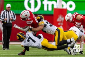 Nebraska Cornhusker running back Emmett Johnson (21) runs with the ball against Iowa Hawkeye defensive back Rashad Godfrey Jr. (7) and linebacker Nolan Delong (31) during a college football game on Friday, Nov. 28, 2025, in Lincoln, Nebraska. Photo by John S. Peterson.