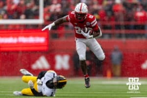 Nebraska Cornhusker running back Emmett Johnson (21) breaks a tackle against Iowa Hawkeye defensive back Xavier Nwankpa (1) during a college football game on Friday, Nov. 28, 2025, in Lincoln, Nebraska. Photo by John S. Peterson.