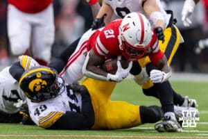 Nebraska Cornhusker running back Emmett Johnson (21) dives over Iowa Hawkeye defensive lineman Ethan Hurkett (49) for extra yards during a college football game on Friday, Nov. 28, 2025, in Lincoln, Nebraska. Photo by John S. Peterson.