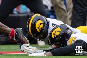 Iowa Hawkeye defensive back Koen Entringer (4) trips up Nebraska Cornhusker running back Emmett Johnson (21) on a long run keeping him from scoring in the first quarter during a college football game on Friday, Nov. 28, 2025, in Lincoln, Nebraska. Photo by John S. Peterson.