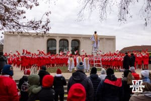 Nebraska Cornhusker fans listen to the Cornhusker Marching Band warm up before heading over to the stadium for a college football game against the Iowa Hawkeyes on Friday, Nov. 28, 2025, in Lincoln, Nebraska. Photo by John S. Peterson.