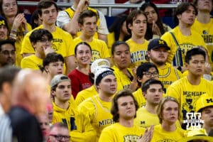 Nebraska Cornhusker fan in the middle of a bunch of Michigan Wolverines students during a college men’s basketball game Tuesday, Jan. 27, 2026, in Ann Arbor, Michigan. Photo by John S. Peterson.