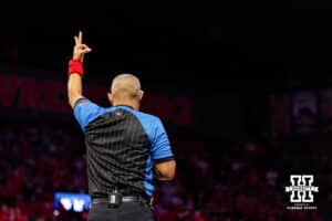 A referee holds up a three signalling for a takedown during a college wrestling dual Friday, Jan. 23, 2026, Lincoln, Nebraska. Photo by Braden Cochran.