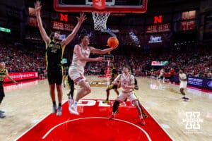 Nebraska Cornhusker forward Pryce Sandfort (21) makes a lay up against Oregon Duck center Nate Bittle (32) in the first half during a college men’s basketball game on Tuesday, Jan. 13, 2026, in Lincoln, Nebraska. Photo by John S. Peterson.