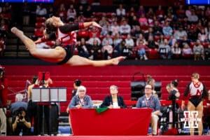 Nebraska Cornhusker Allie Gard leaps in the air in front of judges during the Ameritas Master’s Classic women's gymnastic meet on Saturday, Jan. 10, 2026, in Lincoln, Nebraska. Photo by Braden Cochran.