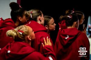 The Nebraska Cornhuskers peek from behind the curtain to watch their hype video for the new season before the Ameritas Master’s Classic women's gymnastic meet on Saturday, Jan. 10, 2026, in Lincoln, Nebraska. Photo by Braden Cochran.