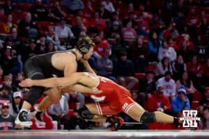 At HWT: #4 Nebraska Cornhusker AJ Ferrari lunges for a take down against Hayden Filipovich, Ferrari wins by major decision 11-2 during a college wrestling match on Friday, Jan. 9, 2026, in Lincoln, Nebraska. Photo by John S. Peterson.