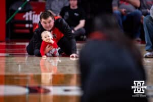 A dad has his baby staged to race to mom in the annual baby race during a college women’s basketball game between the Nebraska Cornhuskers and the Purdue Boilermakers on Sunday, Jan. 4, 2026, in Lincoln, Nebraska. Photo by John S. Peterson.