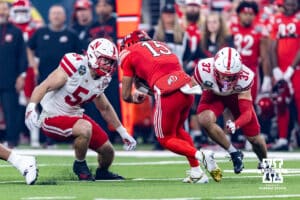 Nebraska Cornhusker linebacker Jacob Bower (54) and defensive back Donovan Jones (37) tackle Utah Ute quarterback Byrd Ficklin (15) during the Las Vegas Bowl game on Wednesday, Dec. 31, 2025, in Las Vegas, NV. Photo by John S. Peterson.