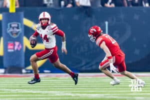 Nebraska Cornhusker quarterback TJ Lateef (14) rolls out with the ball against Utah Ute safety Jackson Bennee (23) in the first quarter during the Las Vegas Bowl game on Wednesday, Dec. 31, 2025, in Las Vegas, NV. Photo by John S. Peterson.
