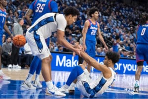 Creighton Bluejay Jasen Green (0) helps up Nik Graves (5) during a college basketball game against DePaul on Feb 25, 2026, in Omaha, Nebraska. Photo by Brandon Tiedemann
