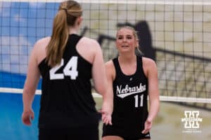 Nebraska Cornhuskers Kenna Cogill (11) and Campbell Flynn (24) give each other five against the Ottawa Braves during a college beach volleyball match on Monday, Feb. 23, 2026, in Lincoln, NE. Photo by John S. Peterson.